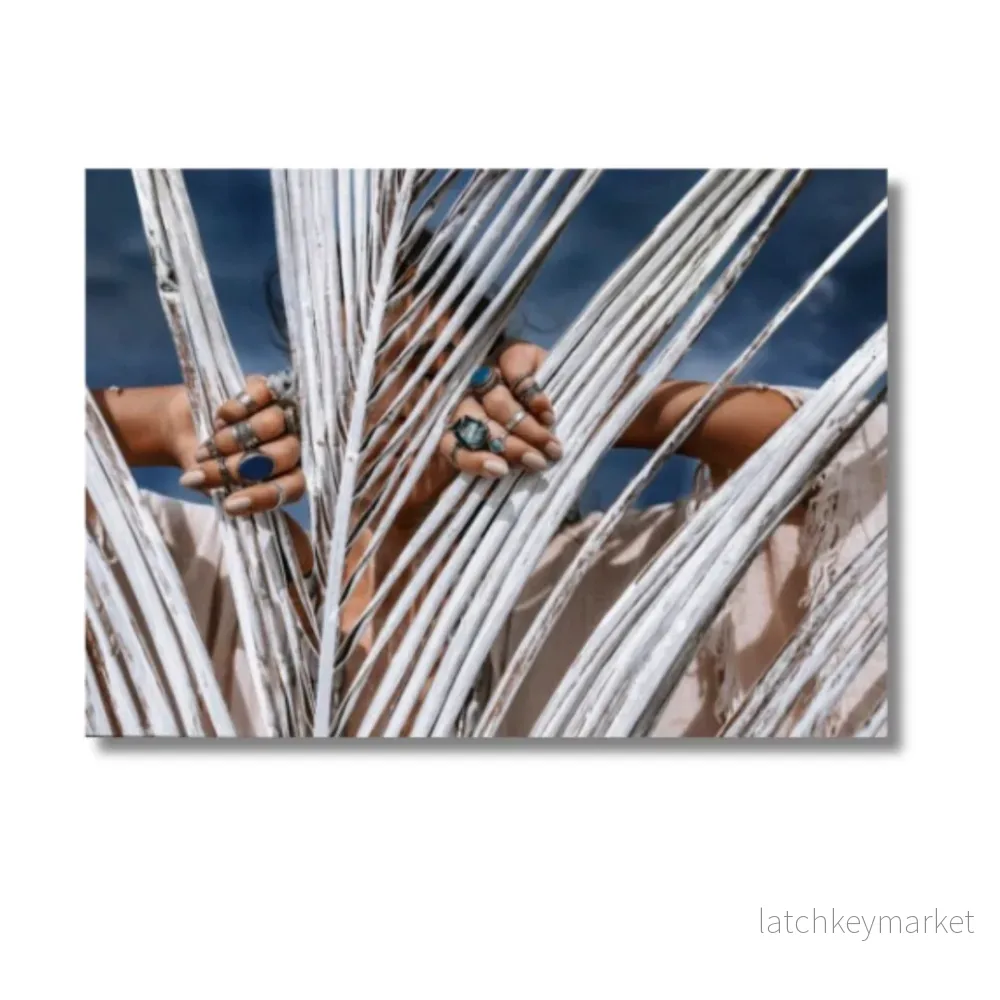 CLOSE UP OF BEAUTIFUL YOUNG TRIBAL STYLE WOMAN WITH LOTS OF ACCESSORIES BEHIND PAINTED WHITE PALM LEAF CLOSE UP OF BEAUTIFUL YOUNG TRIBAL STYLE WOMAN WITH LOTS OF ACCESSORIES BEHIND PAINTED WHITE PALM LEAF
