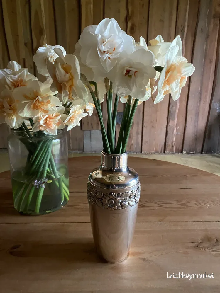 Silvervas med krans av blomstermönster runt om Silvervas med krans av blomstermönster runt om